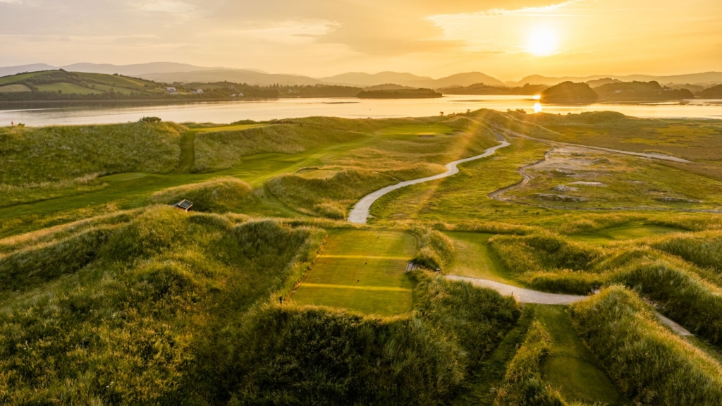 sunset over hole 5 featuring coastal views and grass dunes