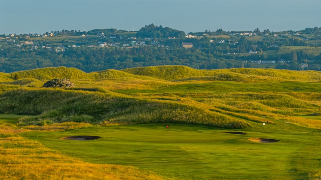 Hole 16 green at Donegal Golf Club, surrounded by links dunes and bunkers with countryside views
