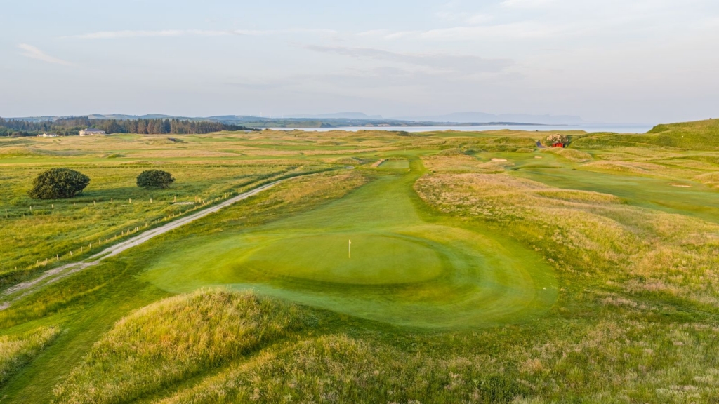 panoramic view of grassy hills and hole on the golf course