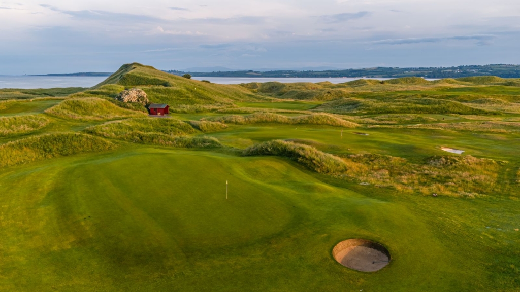 panoramic view of grassy hills and holes on the golf course